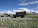 Tibet Kailash 11 Back 06 Gang Benchen to right, Shishapangma in clouds to left From Near Peiku Tso Our Landcruiser had a small problem with everybody trying to help the driver Sadim fix it. On the right of the truck is Gang Benchen (also spelled Gang Benchnen, Chinese: Kangpenqing, 7281m), which was first climbed in 1982 by a Japanese expedition. Many websites show photos of Gang Benchen, but mistakenly call it Shishapangma. Above the Landcruiser with its head in the clouds is Shishapangma.